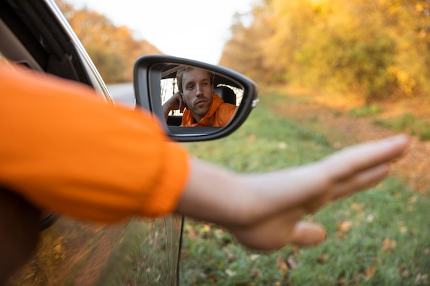 homme-sort-sa-main-voiture-lors-voyage-route-normal